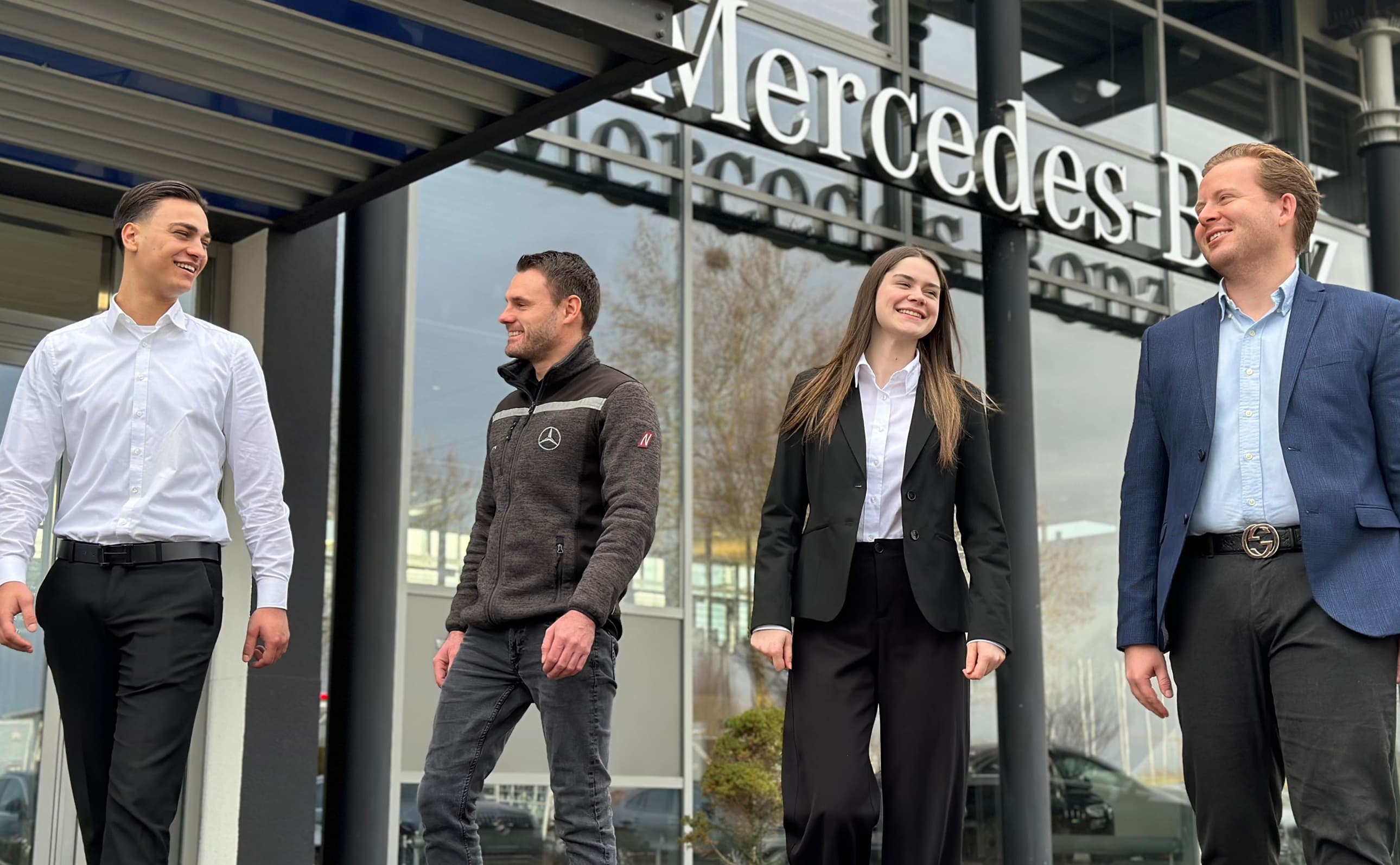 4 Mitarbeiter vor einem Mercedes Autohaus.