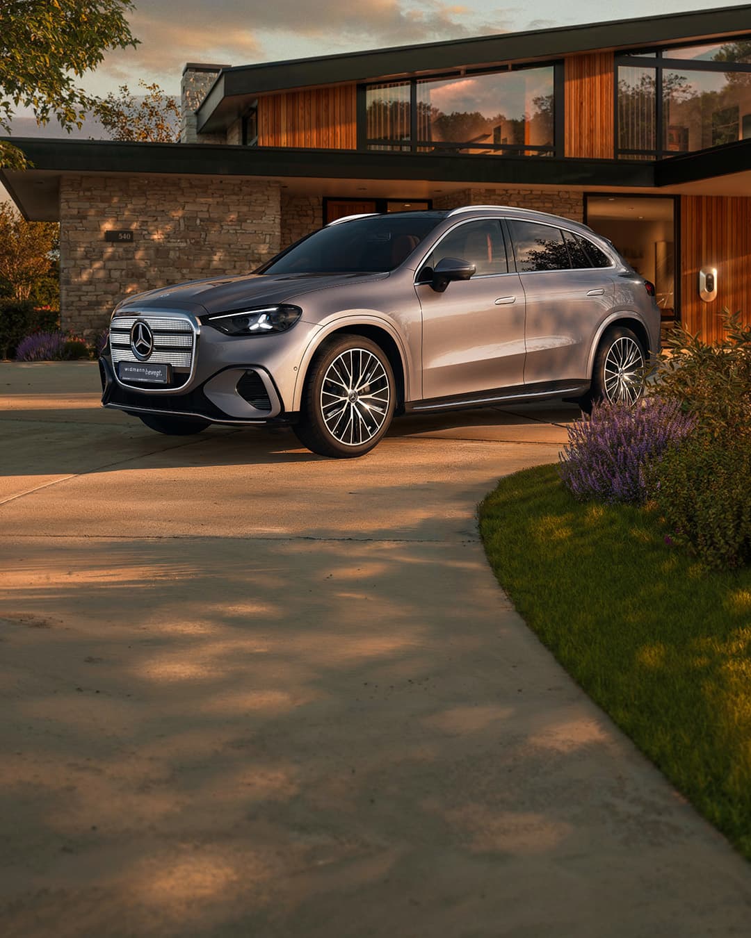 Ein silberner GLC steht in der Einfahrt vor einem Haus