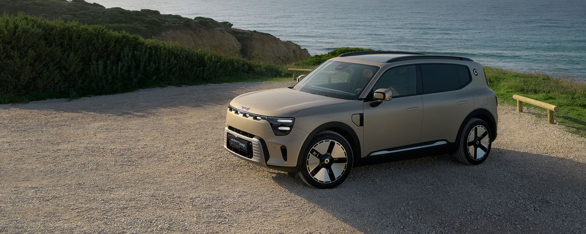 Ein mattbrauner smart #5 fährt auf einer Straße.