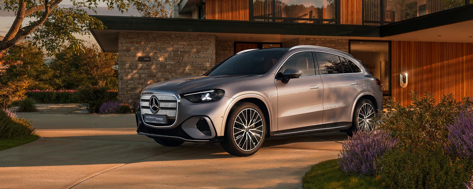 Ein silberner GLC steht in der Einfahrt vor einem Haus