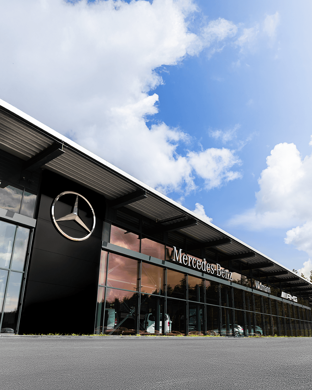 Modernes Mercedes-Benz Autohaus mit großer Glasfassade und Markenlogo an der Außenwand.