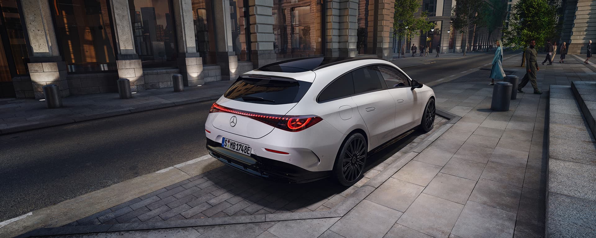 Ein weißer CLA Shooting Brake steht vor einem hohen Gebäude in der Stadt