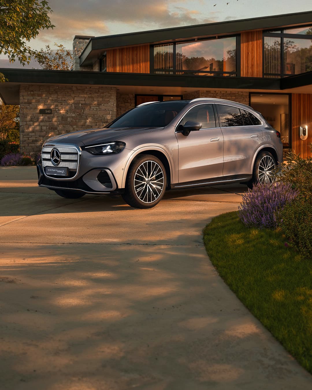 Ein silberner GLC steht in der Einfahrt vor einem Haus