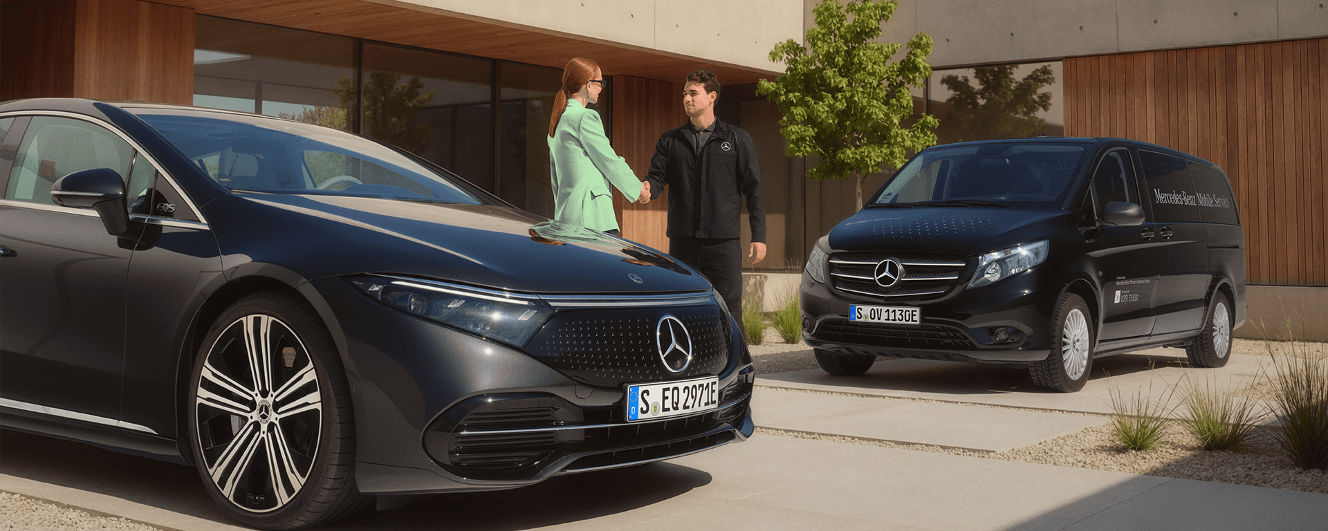 Frau und Mann begrüßen sich per Handschlag neben zwei Mercedes-Fahrzeugen.