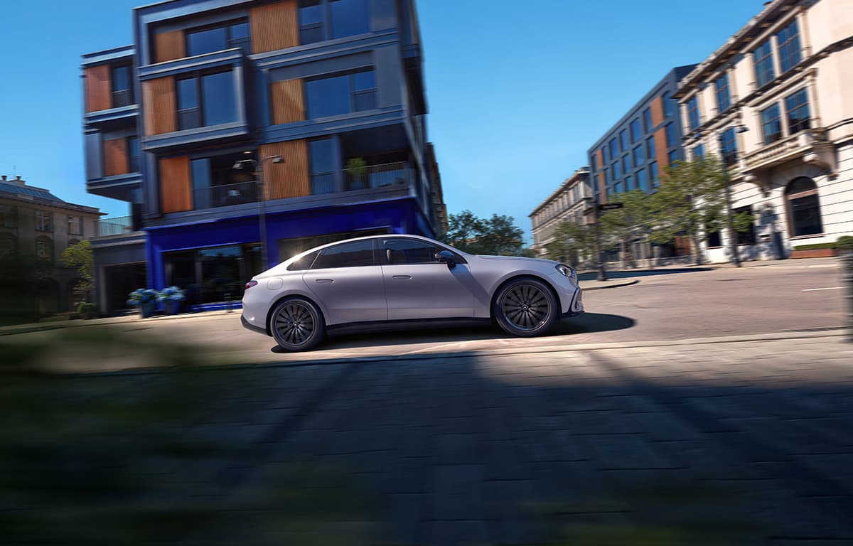 Eine silberne Mercedes-Benz C-Klasse fahrend von der Seite.