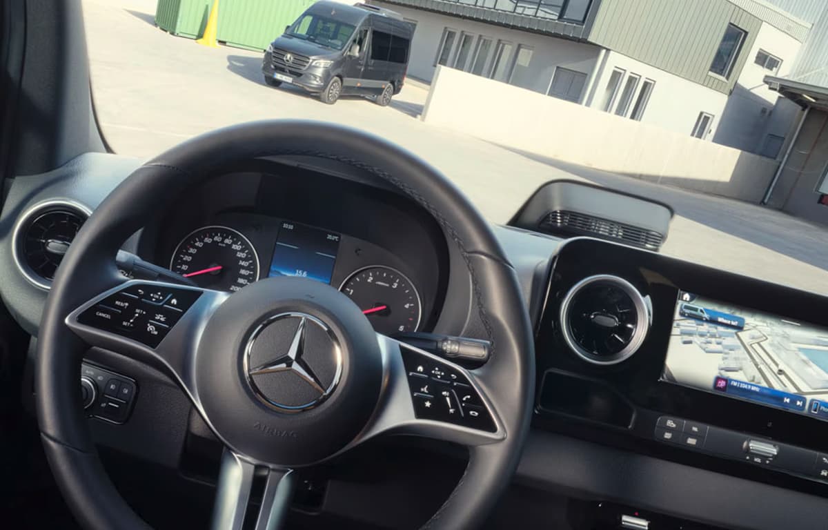 Schräge Ansicht vom Fahrersitz eines Sprinters. Es sind Teile vom Lenkrad und des Armaturenbretts zu sehen. Im Hintergrund durch die Windschutzscheibe ein weiterer Sprinter.