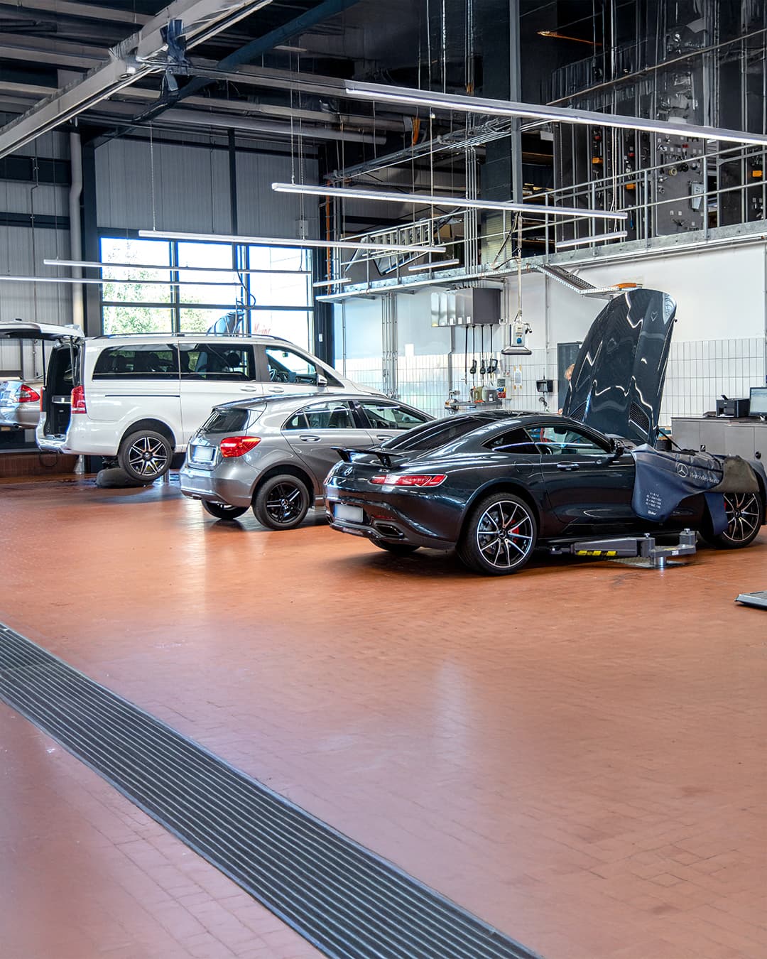 Mehrere MercedesBenz Fahrzeuge in einer Werkstatt