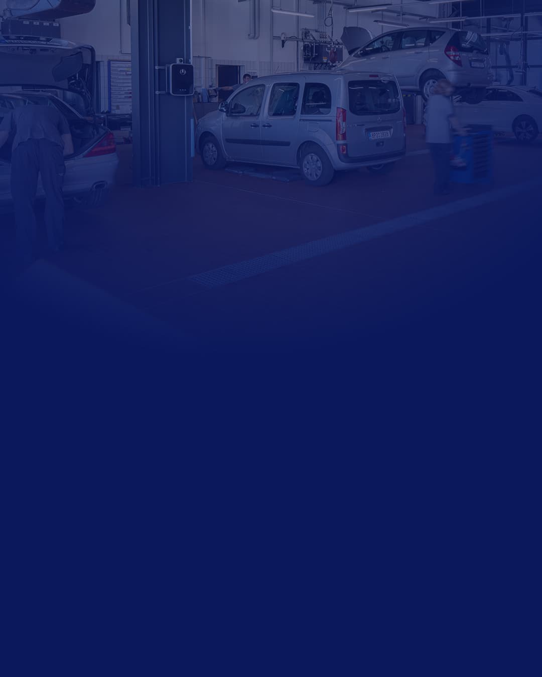 Ein Mitarbeiter eines Autohauses übergibt einen Fahrzeugschlüssel an einen Kunden.