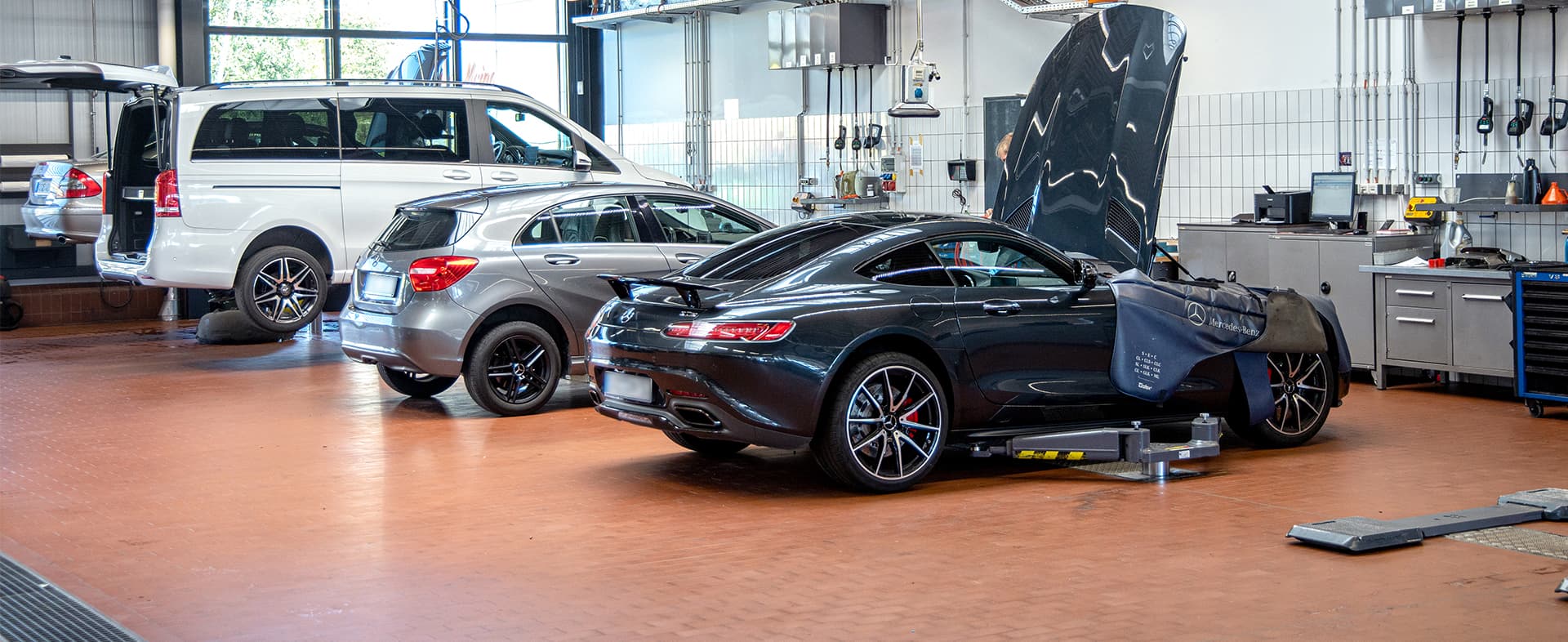 Mehrere MercedesBenz Fahrzeuge in einer Werkstatt
