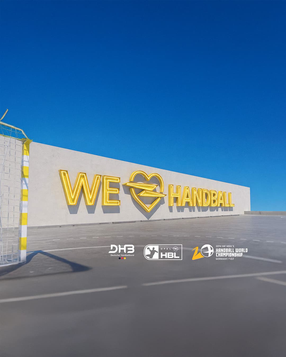 Handballfeld mit „WE LOVE HANDBALL“-Schriftzug sowie den Logos von DHB, HBL und der Handball-Weltmeisterschaft.