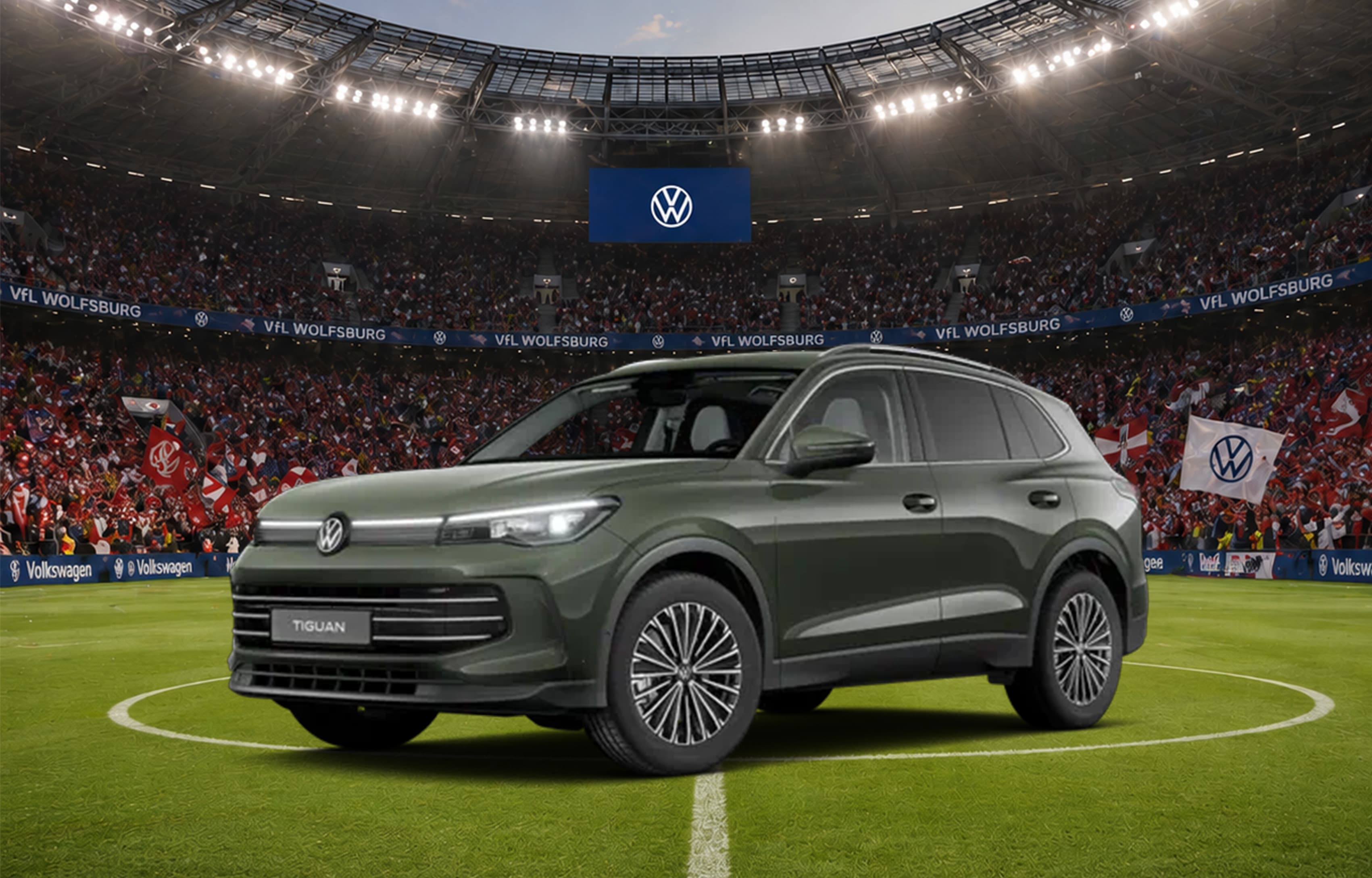 Grüner VW Tiguan im Fußballstadion unter Flutlicht.