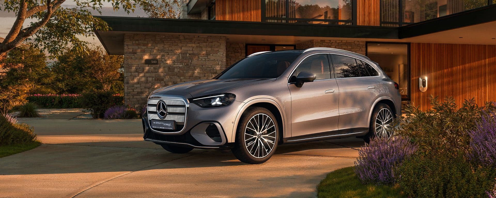 Ein silberner GLC steht in der Einfahrt vor einem Haus